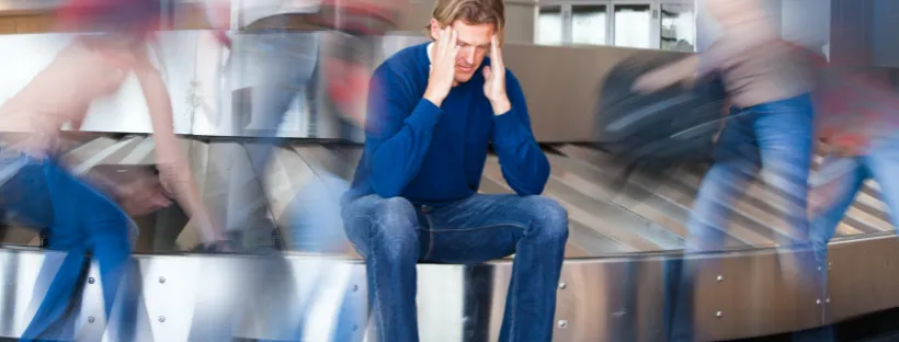 Voyageur inquiet devant un tapis à bagages après la perte ou le retard de sa valise avant une croisi