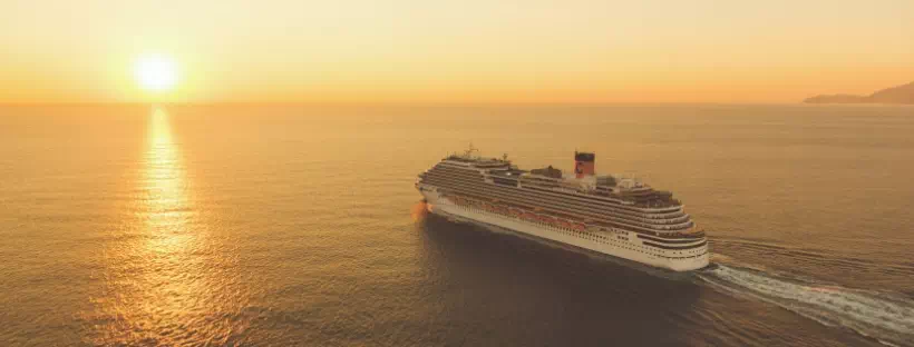 Bateau de croisière s'en allant vers l'horizon, au soleil couchant