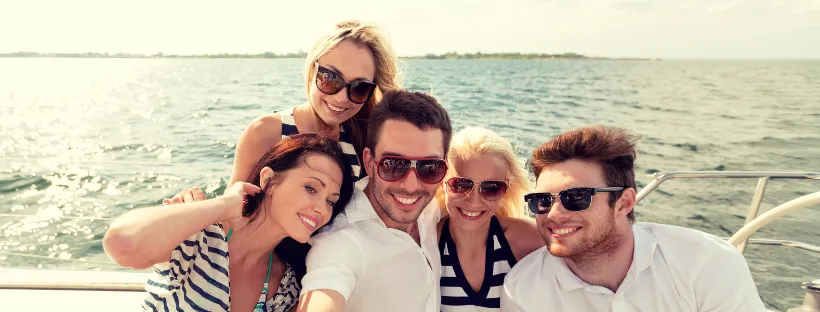 Groupe d'amis souriants sur le pont d'un bateau