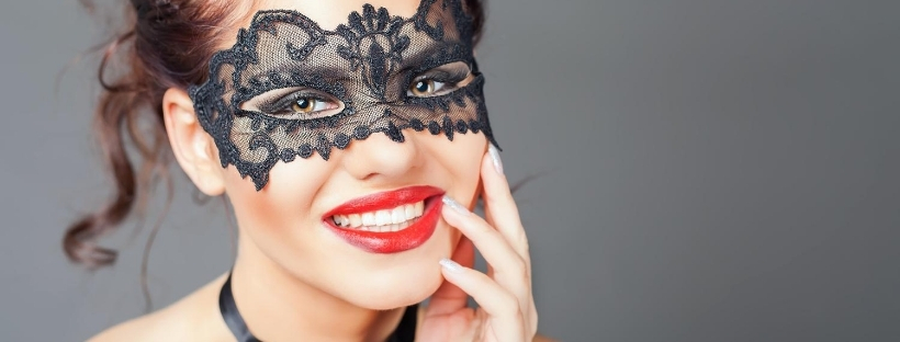 Gros plan visage d'une femme portant un masque sur les yeux, noir en dentelle, et rouge à lèvres rou