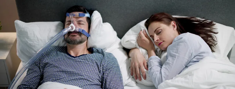 Homme dormant avec un masque pour l’apnée du sommeil