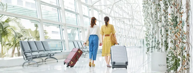 Deux femmes avec valises dans un hall d'embarquement