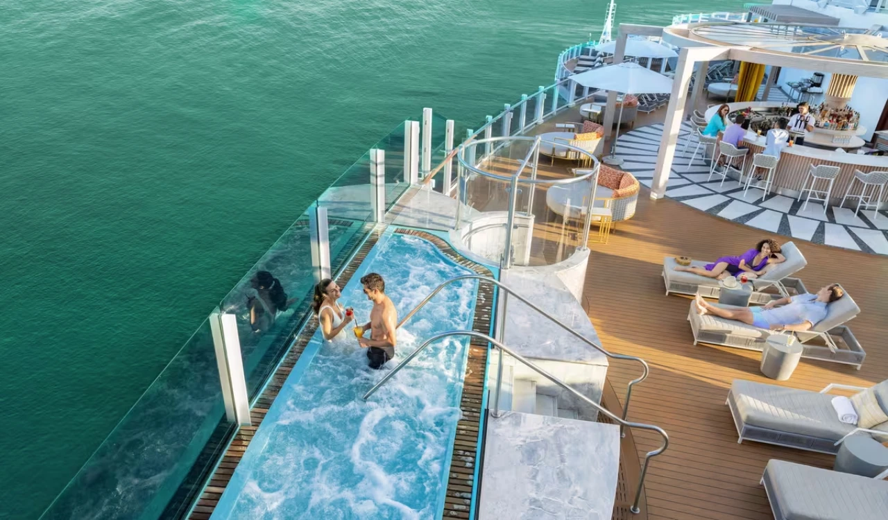 À bord du NORWEGIAN BELLA, des passagers profitent du bain à remous et de l’espace détente.