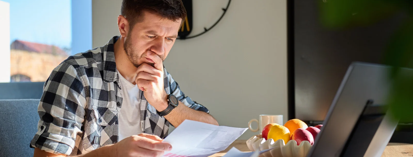 Homme examinant des documents pour vérifier le prix de sa réservation