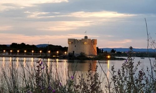 grand lac photographié à l’aube avec à l’arrière-plan un château illuminé