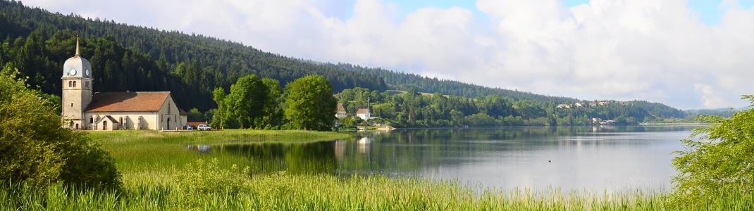 Le lac de l’Abbaye du Jura entouré de verdure