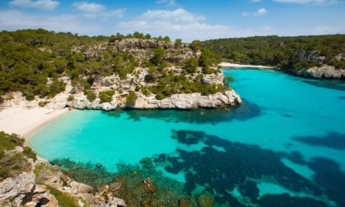 Mer turquoise, bord de mer sable blanc et rocheux, végétation 