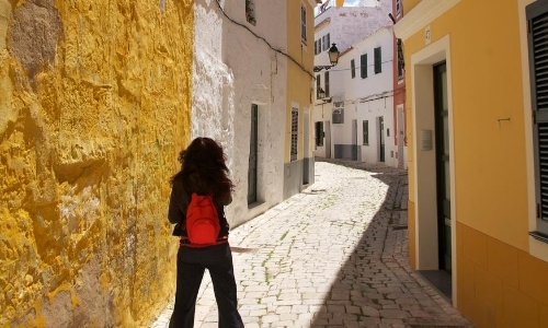 Ruelle avec maisons colorées en jaune, blanc, pavés