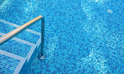 Vue sur une piscine, avant de rentrer dans l'eau par des marches