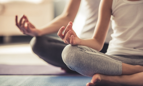 2 personnes faisant du yoga, assises en tailleur 