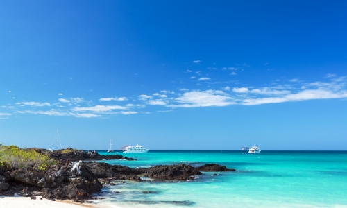 Eaux limpides avec bateaux sur l'eau, ciel bleu et rochers