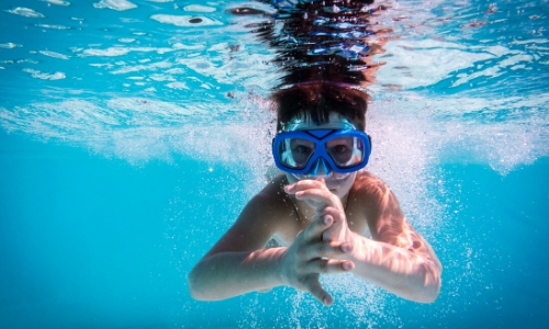 Enfant sous l'eau, dans la piscine avec masque