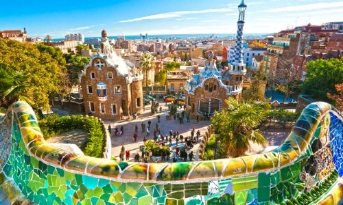 Vue sur le Parc Güell à Barcelone avec beaucoup de couleurs vives, arbres, bâtiments