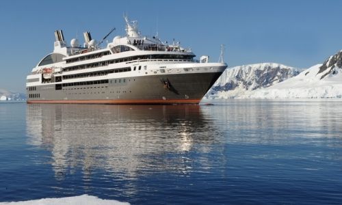 bateau de croisière ponant sur l'eau entouré de glacier