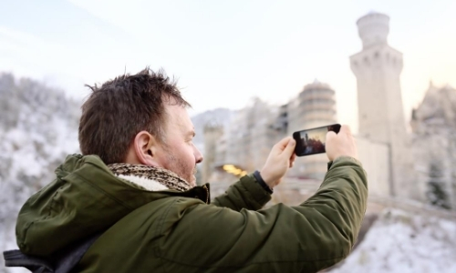 Homme de profil entrain de prendre une photo avec son téléphone