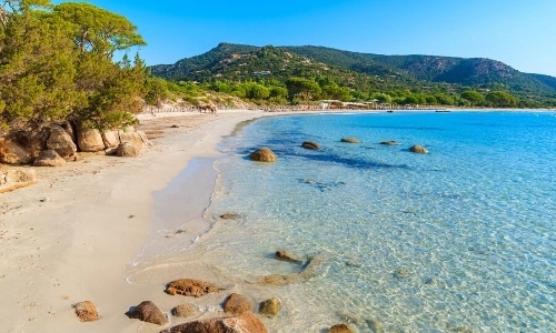 Plage tranquille en Corse, avec sable, et nature, eau cristalline, rochers