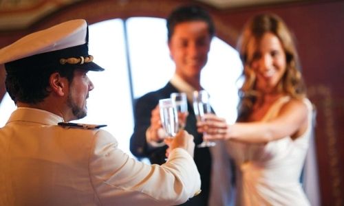 Un membre de l'équipage de Costa Croisières porte un toast avec des passagers