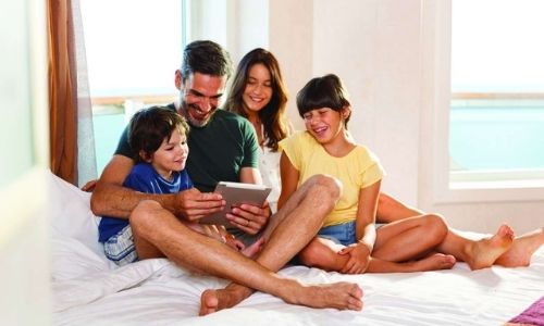 membres d'une famille qui sont assis sur le lit d'une cabine de bateau