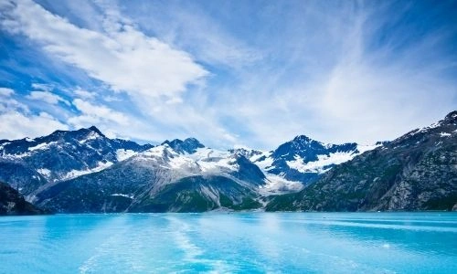 paysages de montagnes, légèrement enneigées avec la mer d’un bleu clair vif au premier plan