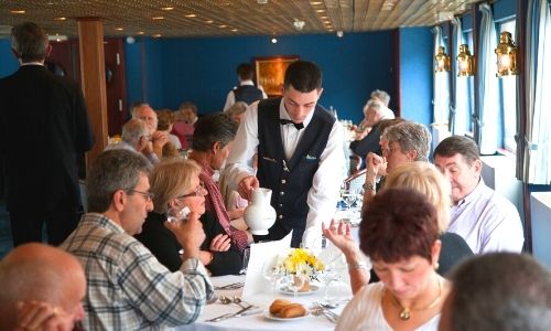 Passagers qui sont à table dans un restaurant du bateau 