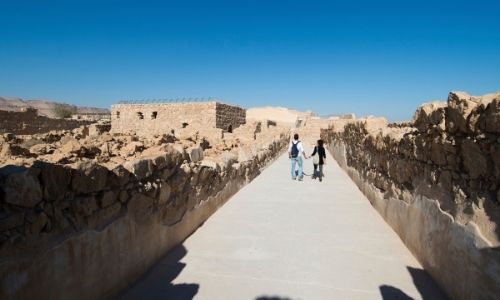 couple qui marche main dans la main dans une ruelle en Arabie Saoudite en pleine journée