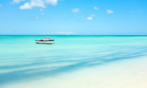 Vue sur les eaux limpides des Caraïbes, avec barque sur l'eau