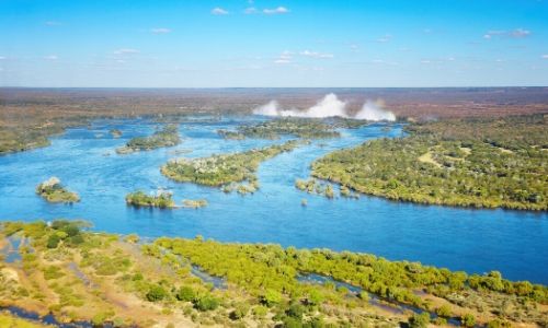 Vue aérienne sur le fleuve Zambèze en Afrique Australe avec végétation et les chutes Victoria