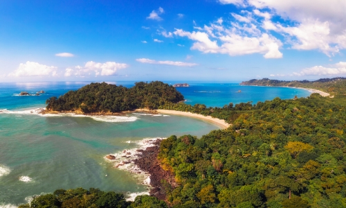 Vue sur la plage du parc national Manuel Antonio, avec arbres, eaux cristallines 