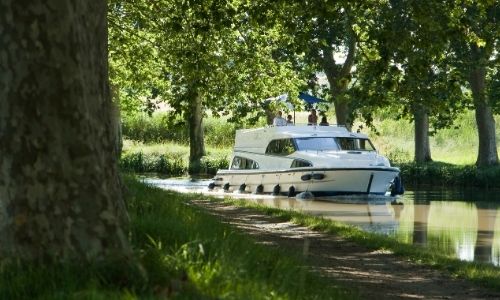 péniche sur un canal français en plein milieu de la nature, des arbres et de verdure