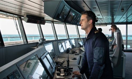 commandant qui pilote le bateau de croisière, regardant à l’horizon dans la salle des contrôles