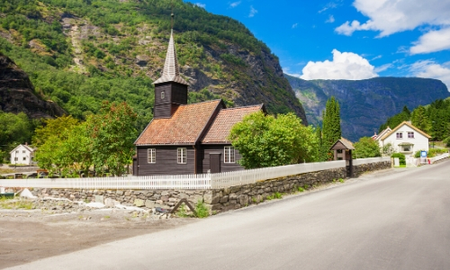 L'église de bois de Flam, en bois de couleur foncée, en plein milieu de la nature, bord d'une route