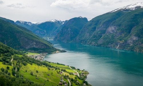 Le Sognefjord, fjord le plus long et profond d'Europe, avec verdure et glaciers en montagnes enneigées au fond