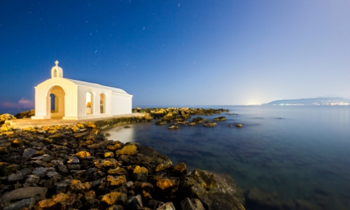 Georgioupolis en Crète, bord de mer avec rochers, et petit bâtiment blanc type religieux