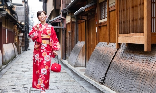 Femme souriante marchant dans la rue en kimono