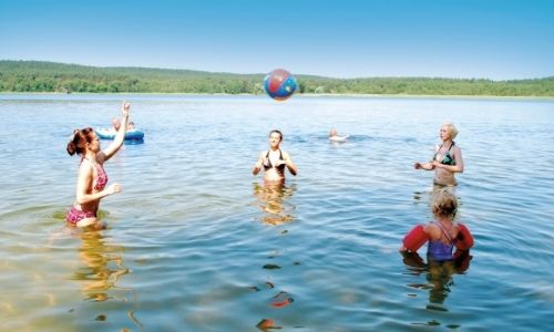 membres d'une famille qui jouent au ballons dans l'eau