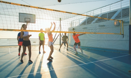 Groupe de personnes jouant au volley ball sur un espace extérieur du bateau dédié