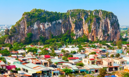 Petites habitations au pieds des montagnes de marbre avec beaucoup de verdure au Vietnam