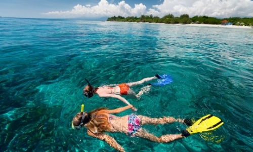 2 personnes entrain de faire du snorkeling dans une eau turquoise