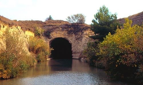 tunnel sur un canal, dont on ne voit pas fond car noir à l’intérieur