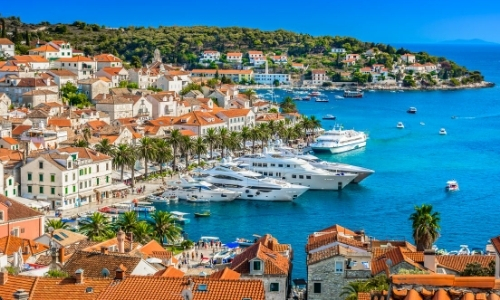 Paysage de Méditerranée avec habitations aux toits oranges, bord de mer, mer turquoise
