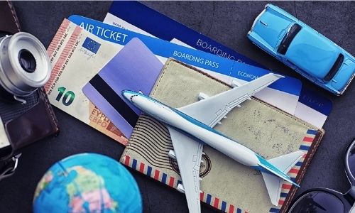 documents essentiels pour un voyage : billets, appareil photo, ticket d'avion, port monnaie, etc