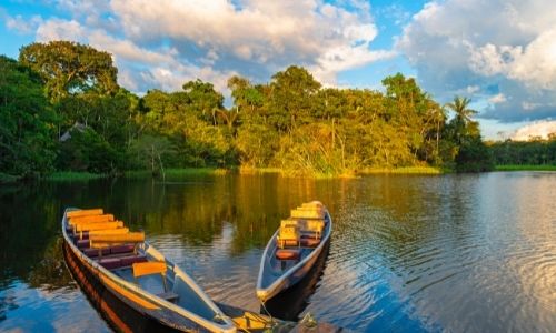 Deux barques sur le fleuve de l'Amazone lors de la golden hour