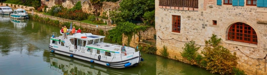Des personnes à bord d'une péniche sur un canal