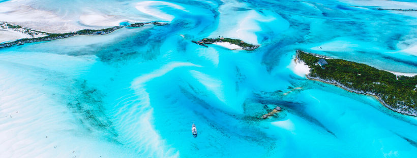 L'eau turquoise et transparente de la mer aux Bahamas dans les Caraïbes avec un voilier