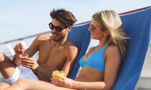 Un couple sur des transats, moments farniente sur le pont du bateau en maillot de bain