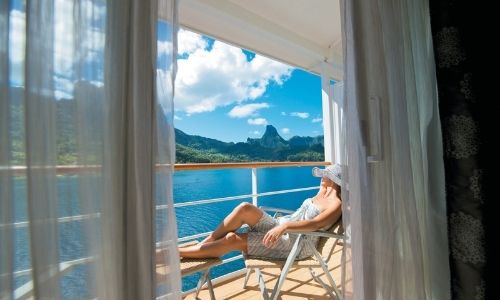 Une cabine du Paul Gauguin donnant vue sur une île polynésienne