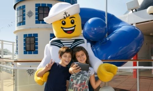 Une figurine Légo et deux enfants prennant un selfi