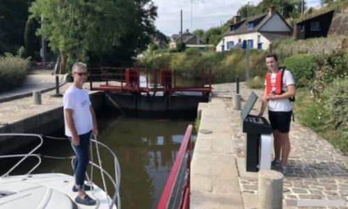 Un touriste de plaisance (sur son bateau sans permis) est aidé par un éclusier 