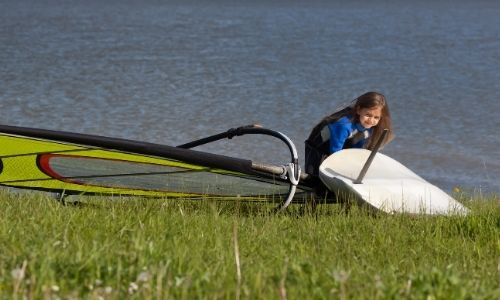 Jeune fille apprend à faire de la planche à voile sur l’étang de Thau