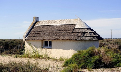 Maison en pierre perdue au milieu d’un lac salé camarguais